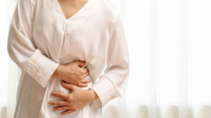 mulher sentindo dor no estômago intestino colon