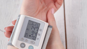 Pessoa medindo a pressão arterial com medidor de pulso, hipertensão